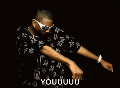A Man Wearing Sunglasses Is Dancing In A Dark Room . GIF
