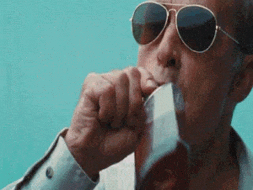 A Man Wearing Sunglasses Is Drinking From A Glass Of Beer . GIF