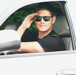 A Man Wearing Sunglasses Is Driving A Car GIF