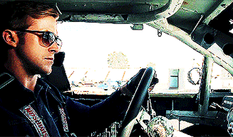 A Man Wearing Sunglasses Is Driving A Car With A Simpson Sticker On His Jacket GIF