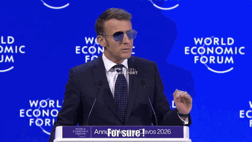 A Man Wearing Sunglasses Is Giving A Speech At The World Economic Forum In 2026 GIF