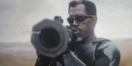 A Man Wearing Sunglasses Is Holding A Camera In His Hand And Pointing It At The Camera . GIF