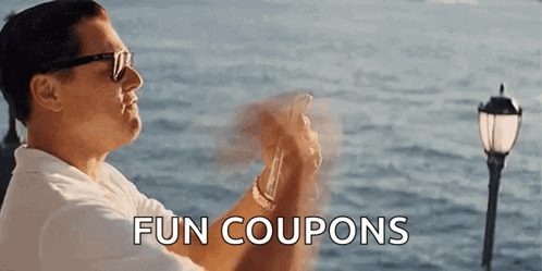 A Man Wearing Sunglasses Is Holding A Cell Phone In Front Of The Ocean And The Words Fun Coupons Are Above Him . GIF