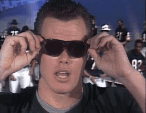 A Man Wearing Sunglasses Is Looking At The Camera . GIF