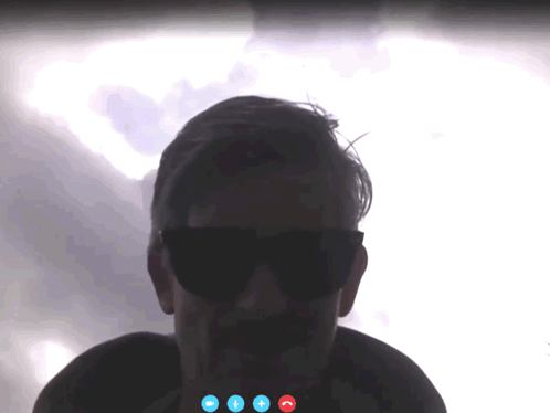 A Man Wearing Sunglasses Is On A Video Call With Three Blue Buttons GIF