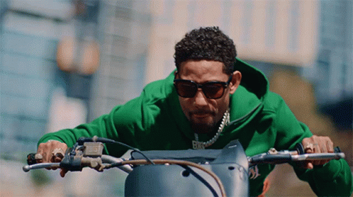 A Man Wearing Sunglasses Is Riding A Motorcycle GIF