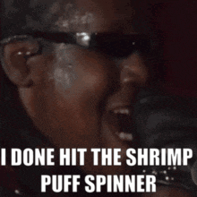 A Man Wearing Sunglasses Is Screaming That He Has Done Hit The Shrimp Puff Spinner GIF