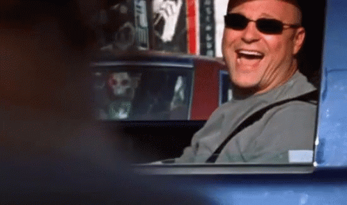 A Man Wearing Sunglasses Is Sitting In A Car And Laughing GIF