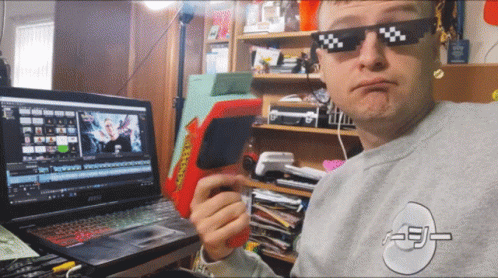 A Man Wearing Sunglasses Is Sitting In Front Of A Msi Laptop Computer GIF