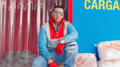 A Man Wearing Sunglasses Is Sitting On Top Of A Pile Of Top Secret Bags GIF