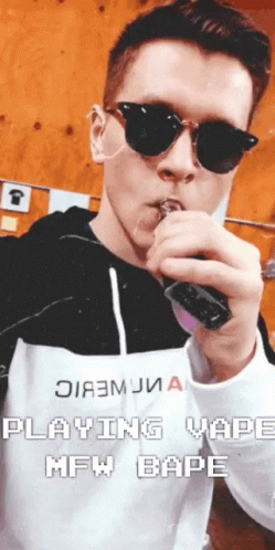 A Man Wearing Sunglasses Is Smoking An Electronic Cigarette With The Words " Playing Vaping Mfw Bape " Below Him GIF
