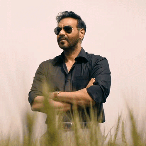 A Man Wearing Sunglasses Is Standing In A Field Of Tall Grass GIF