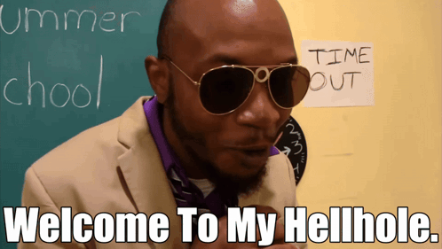 A Man Wearing Sunglasses Is Standing In Front Of A Chalkboard That Says Summer School GIF