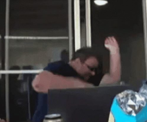 A Man Wearing Sunglasses Is Using A Laptop GIF