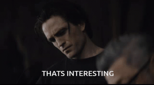 A Man Wearing Sunglasses Says Thats Interesting In A Dark Room GIF