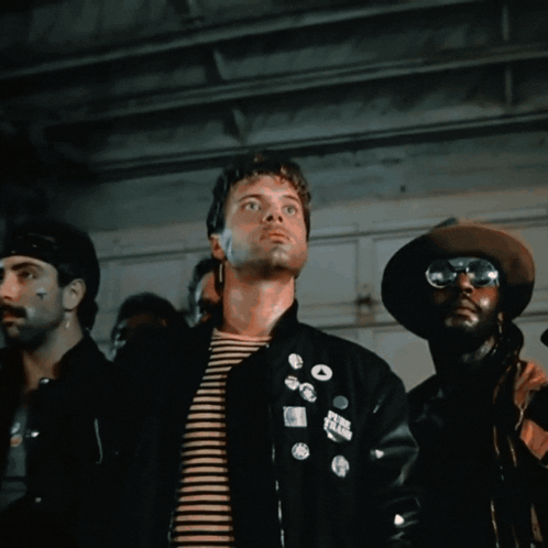 A Man Wearing Sunglasses Stands In Front Of A Cage GIF
