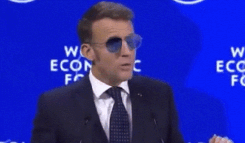 A Man Wearing Sunglasses Stands In Front Of A Sign That Says " For Sure " GIF