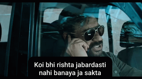 A Man Wearing Sunglasses Talks On A Cell Phone In A Car GIF