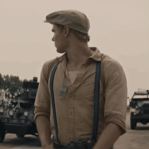 A Man Wearing Suspenders And A Hat With A Tag That Says 90 GIF