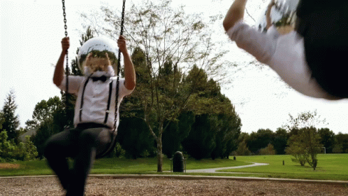 A Man Wearing Suspenders And A Helmet Swings On A Swing GIF