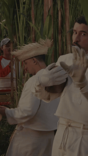 A Man Wearing White Gloves And A Straw Hat Is Playing A Musical Instrument GIF