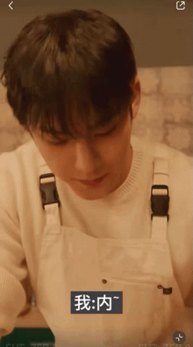 A Man Wearing White Overalls With Chinese Writing On The Bottom Right GIF