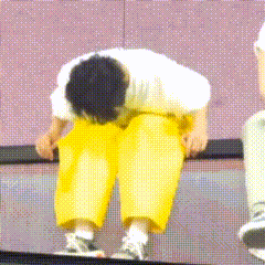 A Man Wearing Yellow Pants And A White Shirt Is Bending Over GIF