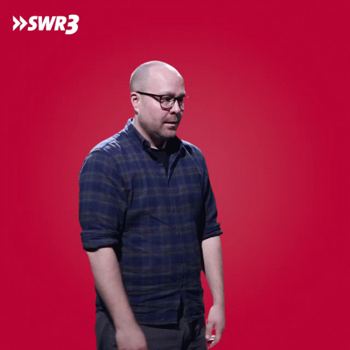 A Man Wipes His Eyes In Front Of A Red Background With The Letters Swr3 On It GIF