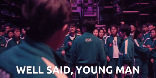 A Man With 226 On His Back Stands In Front Of A Crowd GIF