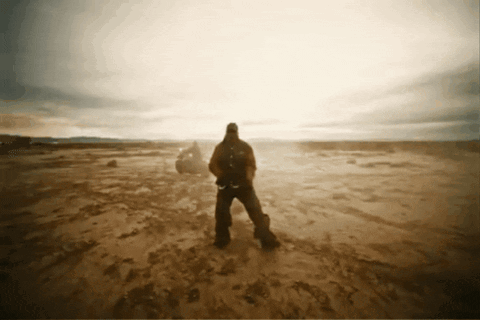 A Man With A Backpack Stands In A Desert GIF