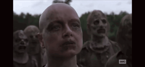 A Man With A Bald Head Is Standing In Front Of A Group Of Zombies With The Letters A And Mc On The Bottom GIF