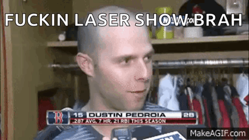 A Man With A Bald Head Is Talking To A Reporter In A Locker Room With The Words Fuckin Laser Show On The Bottom GIF