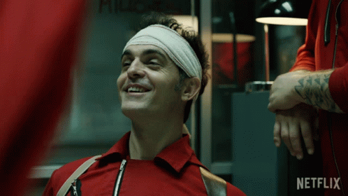 A Man With A Bandage On His Head Is Smiling In Front Of A Netflix Ad GIF