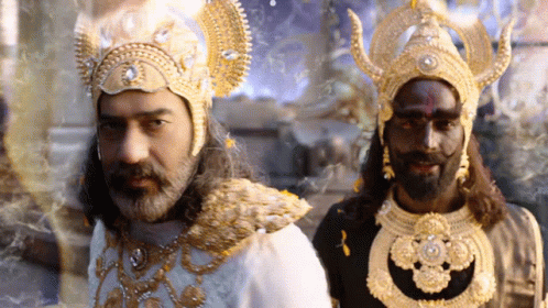 A Man With A Beard And A Black Face Is Standing Next To Another Man In A Costume GIF