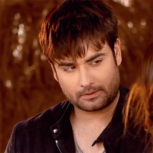 A Man With A Beard And A Black Jacket Looks At The Camera GIF