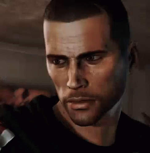 A Man With A Beard And A Black Shirt Is Looking At The Camera . GIF
