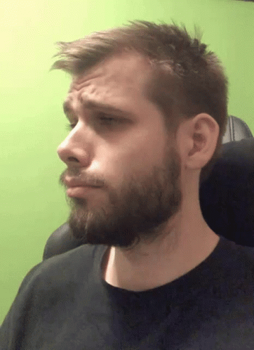 A Man With A Beard And A Black Shirt Is Making A Face GIF