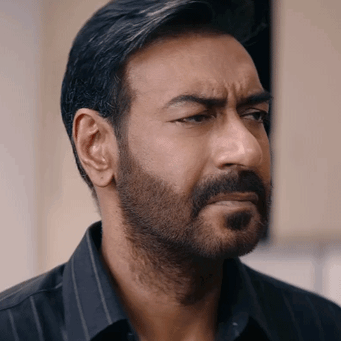 A Man With A Beard And A Black Shirt Looks To The Side GIF