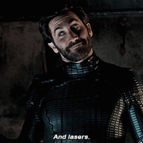 A Man With A Beard And A Black Suit Says And Lasers GIF