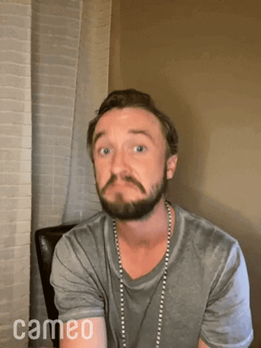 A Man With A Beard And A Cameo Logo On The Bottom Right GIF