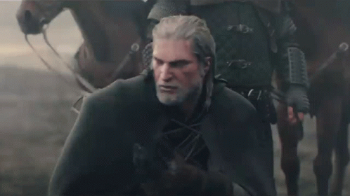 a man with a beard and a cape is standing next to a horse