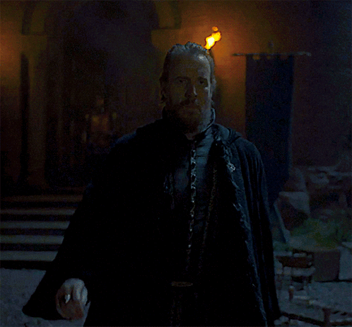 a man with a beard and a cape stands next to another man