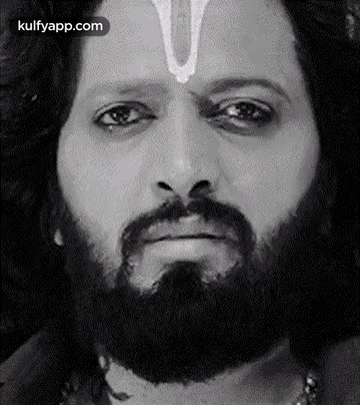 A Man With A Beard And A Cross On His Forehead Is Making A Funny Face . GIF