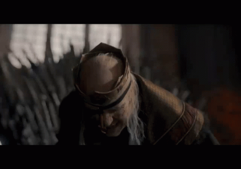 A Man With A Beard And A Crown On His Head Looks To The Side GIF