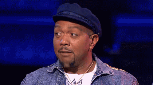 A Man With A Beard And A Hat Is Making A Funny Face . GIF