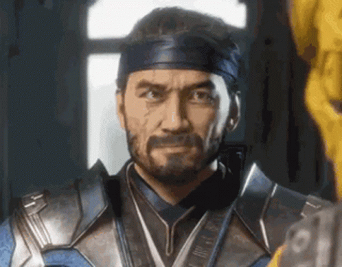 A Man With A Beard And A Headband Is Standing In Front Of A Window In A Room . GIF
