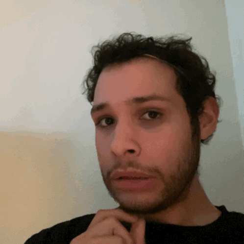 A Man With A Beard And A Headband On His Head Looks At The Camera GIF