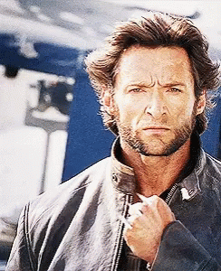 A Man With A Beard And A Leather Jacket Looks At The Camera GIF
