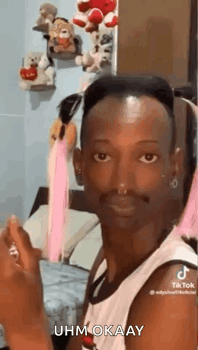 A Man With A Beard And A Nose Ring Is Sitting In A Bedroom . GIF