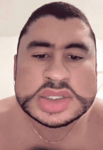 A Man With A Beard And A Nose Ring Is Wearing A Necklace GIF